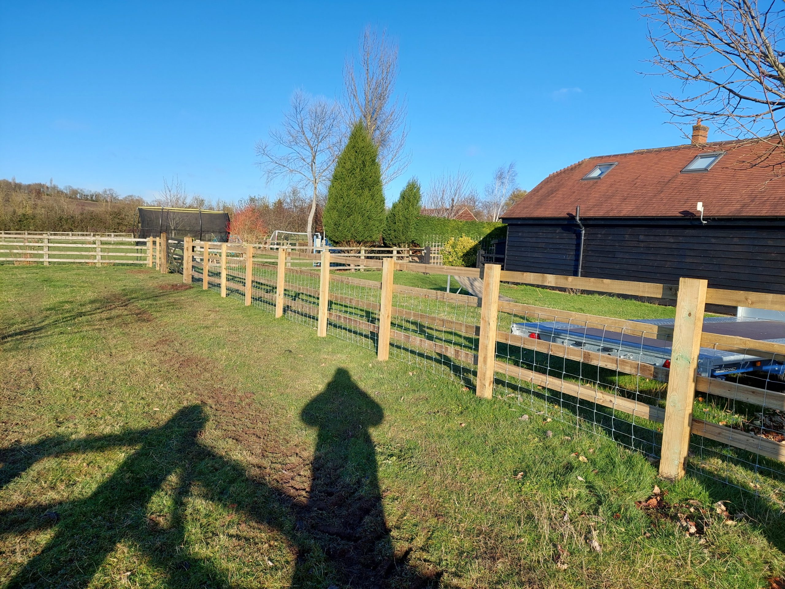 Post and rail fence on a sunny open field