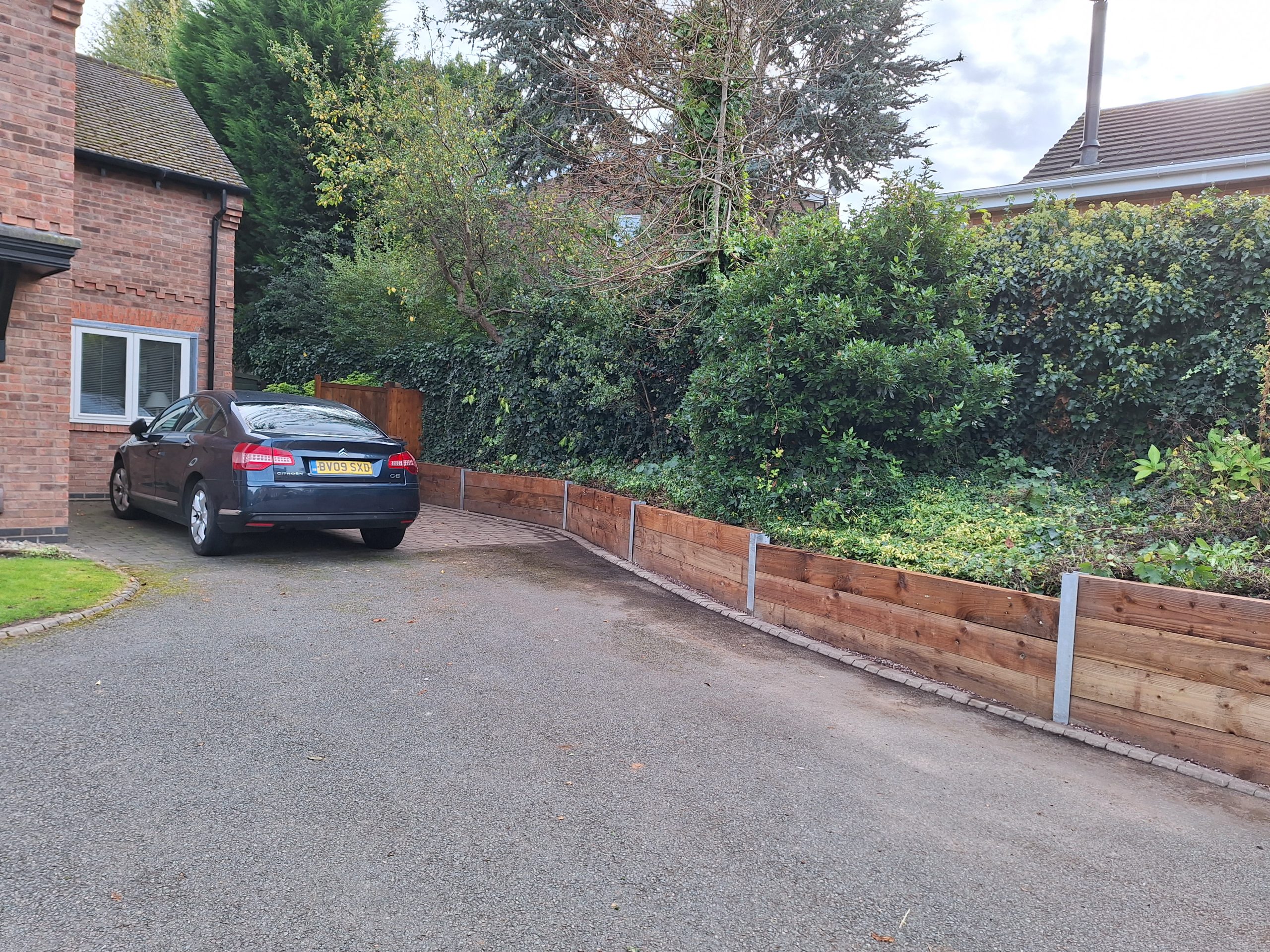 Timber sleeper retaining wall along driveway