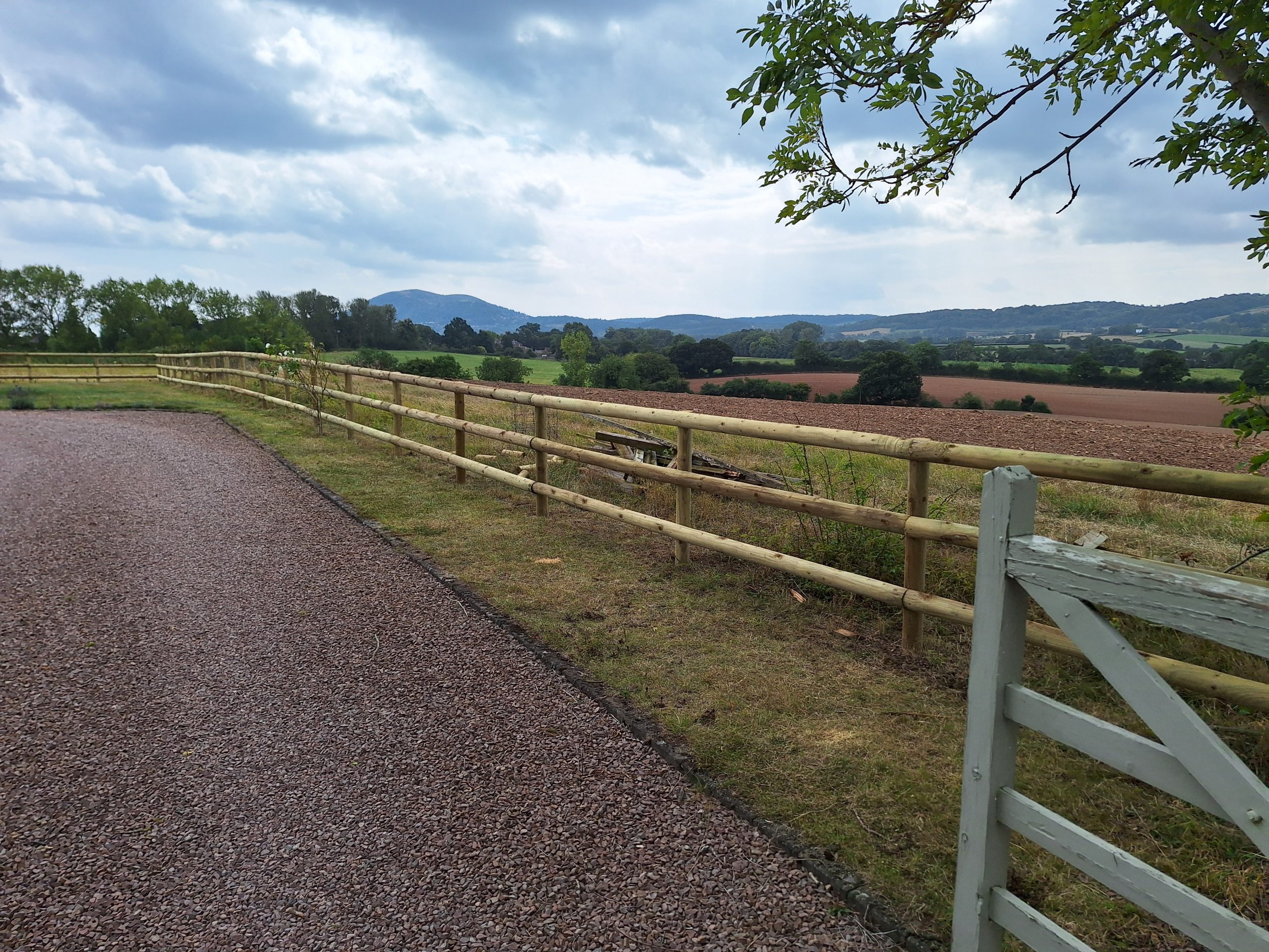 Long post and rail fence along gravel driveway, Malvern Hills